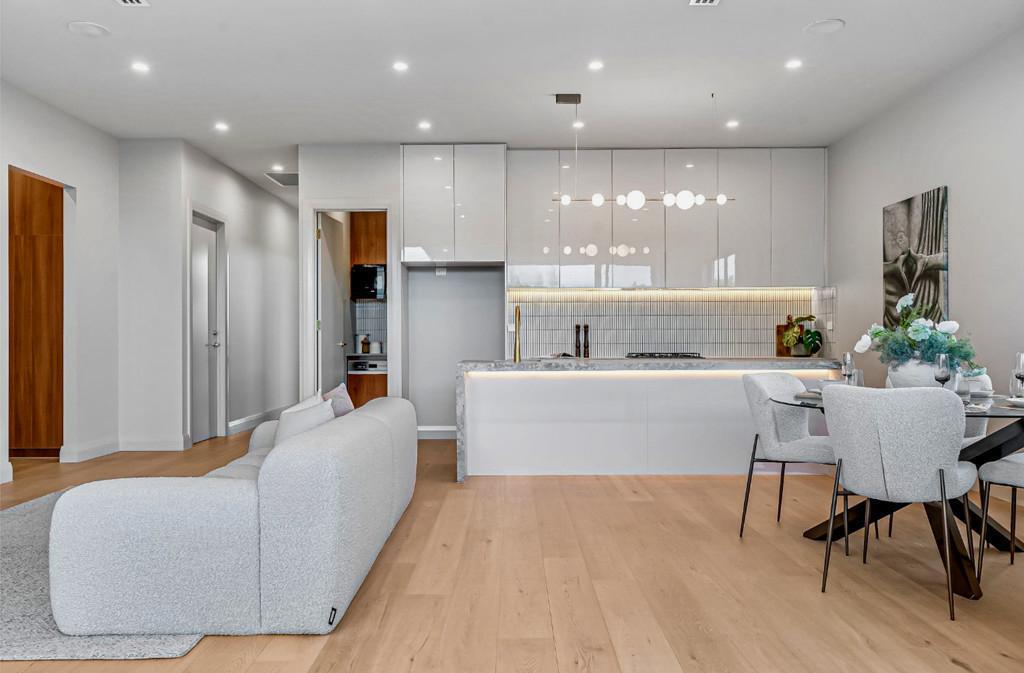 High-gloss white kitchen with stone waterfall island